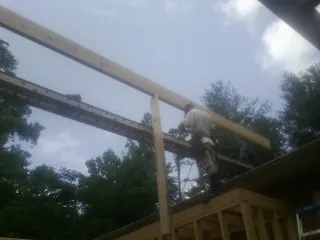 Carpenter setting a ridge beam over a new addition frame — Ice Dam Removal by Roofing Brothers in Pocatello