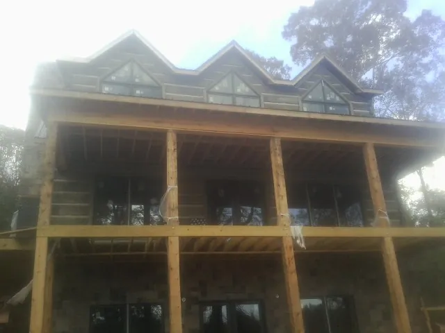 Dormers and porch framing on a large log home under construction — Roof Coating work by our crew in Pocatello