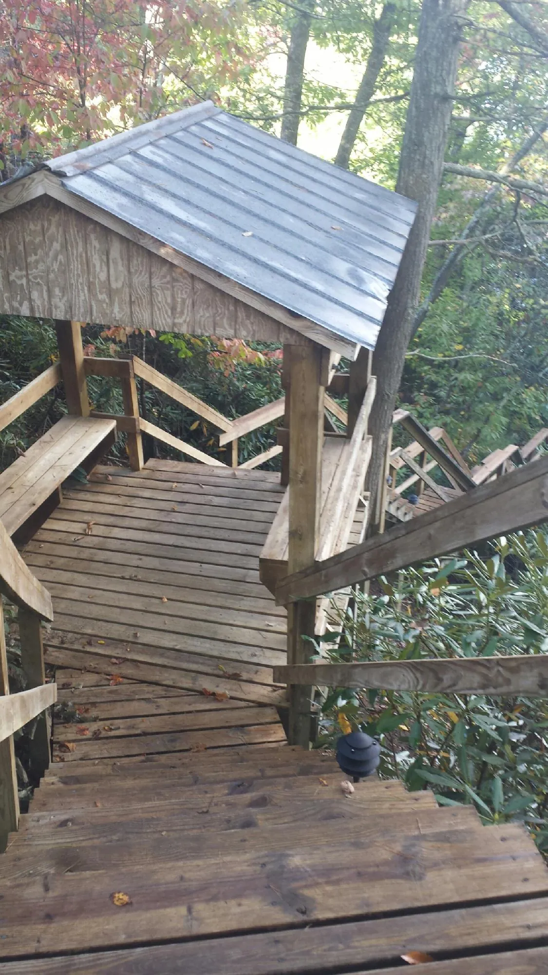 Metal roofed shelter over wooden steps on a wooded walkway — Skylight Repair & Installation work by our crew in Pocatello
