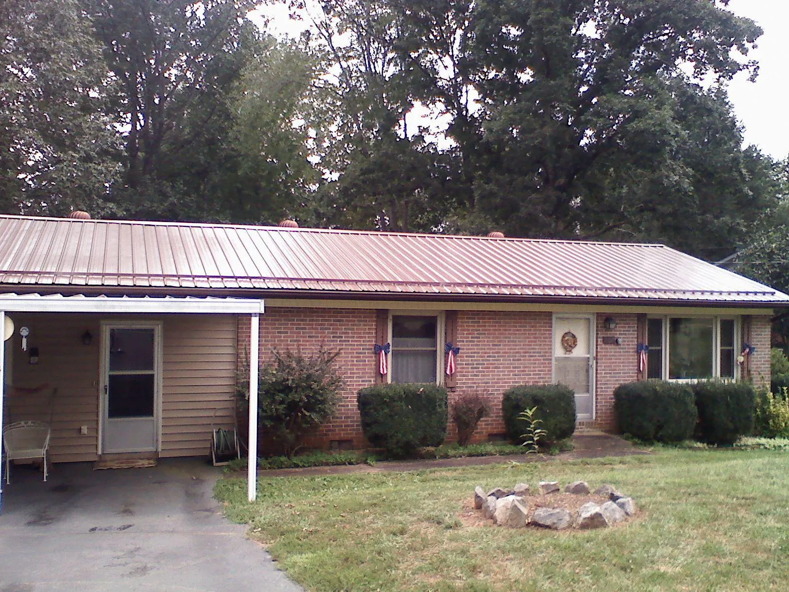 Bronze metal roof and carport on a brick ranch home — Roof Repair work by our crew in Pocatello